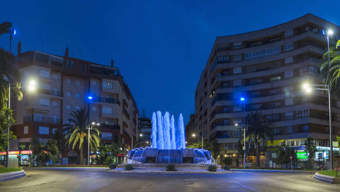 La place avec sa fontaine illuminée par l'éclairage Philips dans le cadre du projet Bastions de lumière