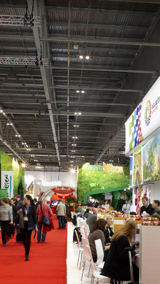 Des stands au centre ExCeL London, mis en lumière par une solution d'éclairage grande hauteur innovante de Philips