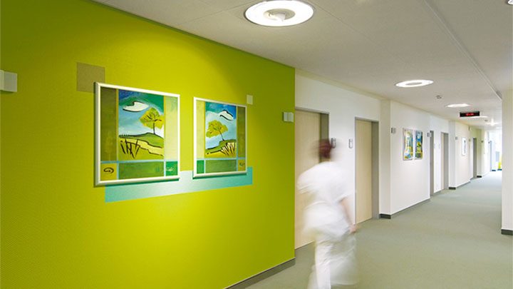 Une infirmière marche dans un couloir éclairé par Philips dans la clinique psychiatrique