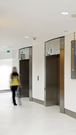 Les couloirs et ascenseurs du bâtiment Tower 42, mis en lumière par une solution d'éclairage pour bureaux de Philips