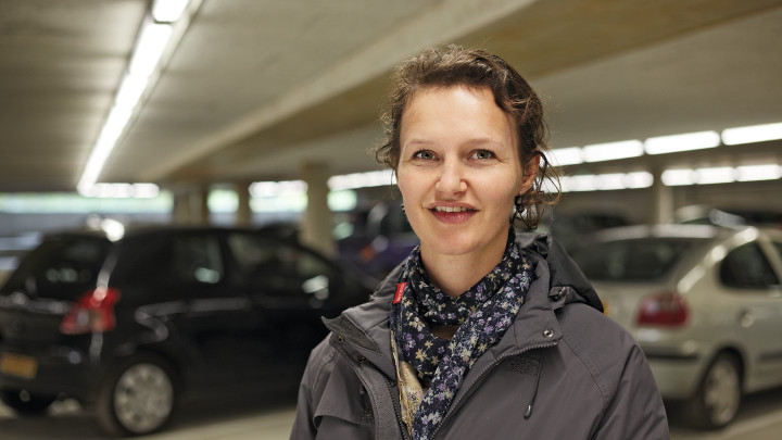  Des femmes souriantes devant des voitures garées dans le parking Eiteren, éclairé par un système Philips 