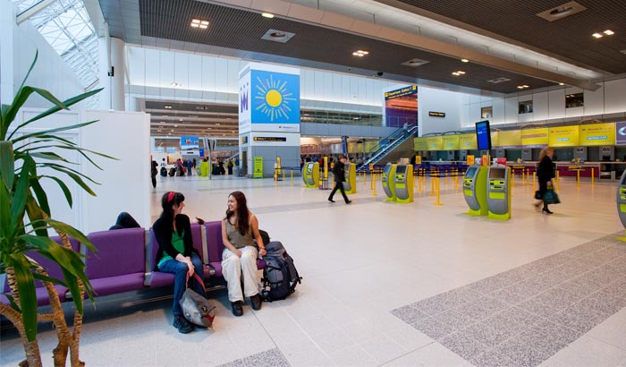 Deux femmes discutent sous un plafond LED lumineux dans le terminal 2 de l’aéroport de Manchester