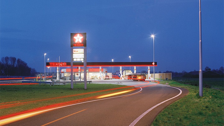 Une station Texaco à côté de l’autoroute, joliement éclairée au crépuscule – un éclairage extérieur attractif