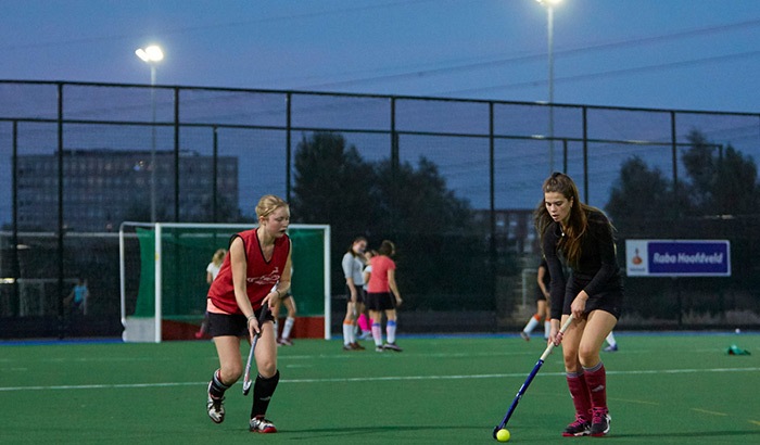 Two girls playing hockey on the fields of AHC Ijburg